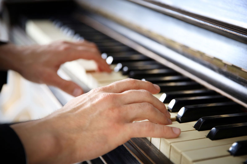 A closeup of hands on the piano.